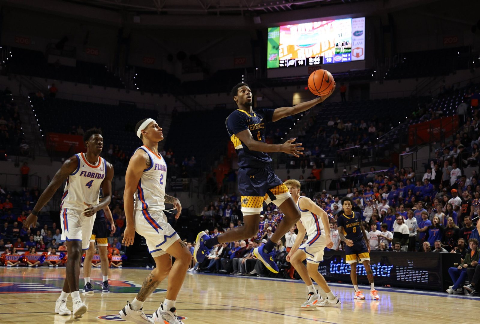Coach Samba driving to the basket for a layup in a college game